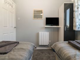 A bedroom with a television and twin beds at Ty Glan Morfa in Morfa Bychan