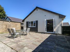 An outdoor patio area with a table and chairs at Ty Glan Morfa in Morfa Bychan