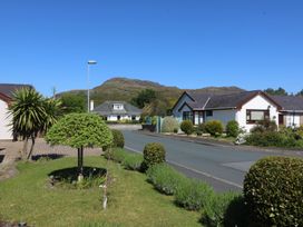 Houses along a road with a mountain in the background at Ty Glan Morfa, Morfa Bychan