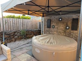 A hot tub under a canopy in a garden at Ty Glan Morfa in Morfa Bychan