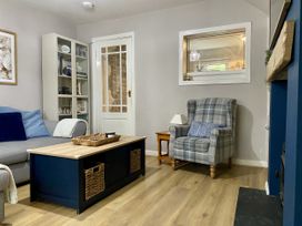 A living room with a coffee table and armchair at Waterfall Cottage in Dyserth