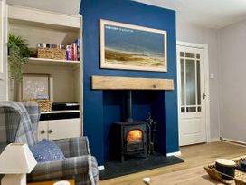 A living room with a fireplace and bookshelf at Waterfall Cottage in Dyserth