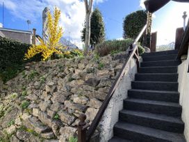 A garden with stairs and a yellow plant at Waterfall Cottage Dyserth