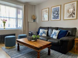 A living room with a sofa coffee table and decorative items at Waterfall Cottage Dyserth