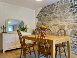 A dining room with a table and chairs at Waterfall Cottage in Dyserth
