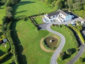 A house with a pond and landscaped garden at Top Of The Lane Luxury Holiday Apartment in Benllech