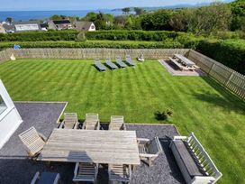 A garden with table and chairs at Top Of The Lane Luxury Holiday Apartment in Benllech