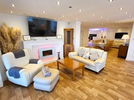 A living room with a sofa and armchair in Top Of The Lane Luxury Holiday Apartment in Benllech
