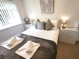 A bedroom with a bed and bedside lamps at Top Of The Lane Luxury Holiday Apartment in Benllech