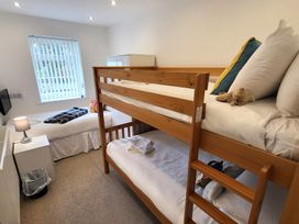 A bedroom with a bunk bed and a single bed at Top Of The Lane Luxury Holiday Apartment in Benllech
