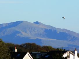 A view of mountains and houses with a bird in flight at Top Of The Lane Luxury Holiday Apartment in Benllech