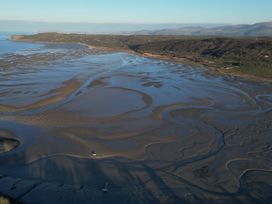 A view of a coastal area with sand and water at Top Of The Lane Luxury Holiday Apartment in Benllech