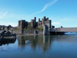 A castle beside a river with a bridge at Top Of The Lane Luxury Holiday Apartment Benllech