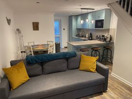 A living room with a sofa and dining area at 51 Fernhill Heights in Charmouth