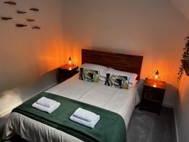 A bedroom with a bed and bedside tables at 51 Fernhill Heights Charmouth