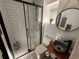 A bathroom with shower, toilet, sink, and mirror at 51 Fernhill Heights in Charmouth