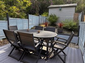 A garden with a table and chairs at 51 Fernhill Heights Charmouth