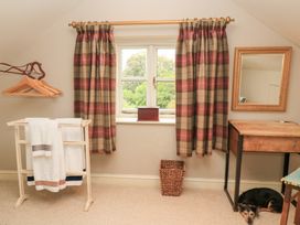 A bedroom with a window and towels on a rack at Pudding Hill Barn Cottage Bibury