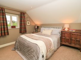 A bedroom with a bed and bedside table at Pudding Hill Barn Cottage Bibury