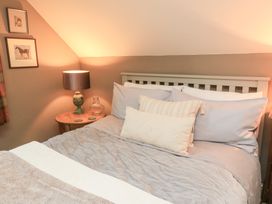A bedroom with a bed and lamp at Pudding Hill Barn Cottage in Bibury