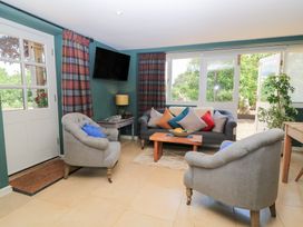 A snug with a couch and coffee table at Pudding Hill Barn Cottage Bibury