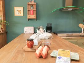 A kitchen with a wooden island and various items including eggs and a toaster at Pudding Hill Barn Cottage in Bibury