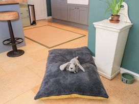 A dog bed with a toy in a kitchen at Pudding Hill Barn Cottage Bibury