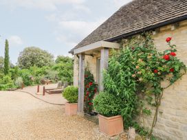 An outdoor area with a stone wall and plants at Pudding Hill Barn Cottage Bibury