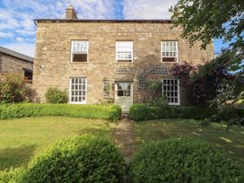 A stone building with greenery and windows at Garsdale Foot in Sedbergh