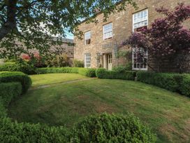 A garden with grass and bushes in front of a building at Garsdale Foot Sedbergh