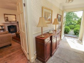 A hallway with a console table and lamps leading to a garden at Garsdale Foot in Sedbergh