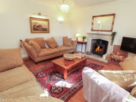 A living room with a fireplace and sofa at Garsdale Foot in Sedbergh