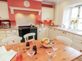 A kitchen featuring an oven, sink, table with fruit and drinks at Garsdale Foot Sedbergh