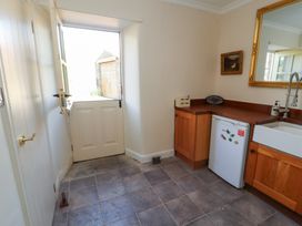 A kitchen with a fridge, sink, and counter at Garsdale Foot in Sedbergh