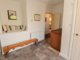 A hallway with a bookshelf and wooden bench at Garsdale Foot in Sedbergh