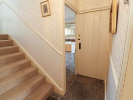 A hallway with stairs and a door leading to the kitchen at Garsdale Foot in Sedbergh