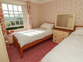 A bedroom with two beds and a mirror at Garsdale Foot in Sedbergh