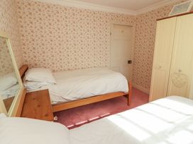 A bedroom with two beds and a wardrobe at Garsdale Foot Sedbergh