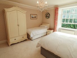 A bedroom with two beds and an armoire at Garsdale Foot in Sedbergh