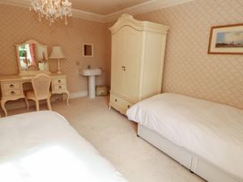 A bedroom with a bed, wardrobe, and vanity at Garsdale Foot, Sedbergh
