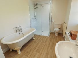 A bathroom with a bathtub, shower, toilet, and sink at Garsdale Foot in Sedbergh