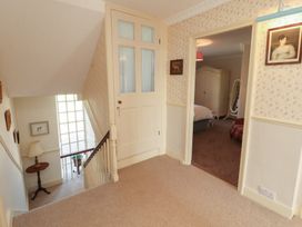 A hallway with stairs and a door leading to a bedroom at Garsdale Foot in Sedbergh