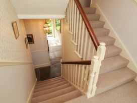 A staircase with a light fixture and framed pictures at Garsdale Foot Sedbergh