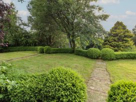A garden with bushes and a pathway at Garsdale Foot in Sedbergh