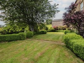 A garden with a tree and hedges at Garsdale Foot in Sedbergh