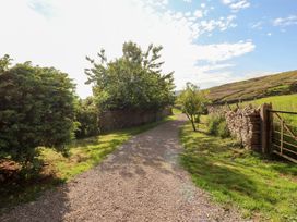 A gravel path surrounded by trees and a stone wall at Garsdale Foot Sedbergh