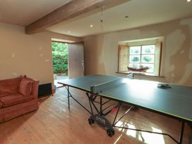 A room with a ping pong table and a sofa at Garsdale Foot in Sedbergh