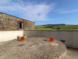 A stone table with glasses in an outdoor seating area at Garsdale Foot in Sedbergh