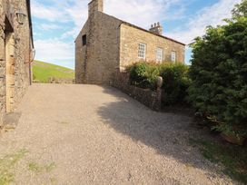 A gravel driveway leading to stone buildings at Garsdale Foot in Sedbergh