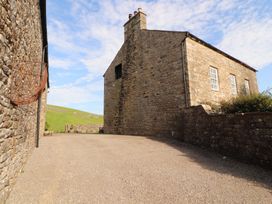 An outdoor area with stone buildings and a gravel driveway at Garsdale Foot Sedbergh